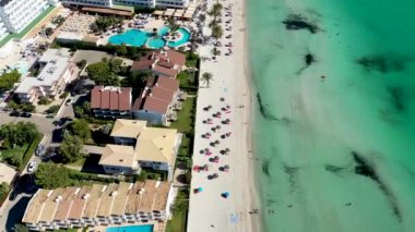 Aerial drone footage of the beach front on the Spanish island Majorca Mallorca, Spain showing the beach known as Platja de Muro in the village of Alcdia on a sunny summers days