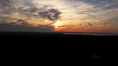 Aerial drone footage showing the sunset over looking a large amount of trees located on Prince Edward Island in Canada in. the autumn fall time, showing the beautiful surroundings at dusk