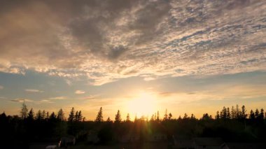Aerial drone footage showing the sunset over looking a large amount of trees located on Prince Edward Island in Canada in. the autumn fall time, showing the beautiful surroundings at dusk
