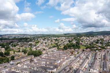 Lancashire İngiltere 'deki Burnley kasabasının hava aracı fotoğrafı güneşli bir yaz gününde İngiliz konutlarının ve banliyö sokaklarının sıralı Victoria teras evlerinin insansız hava aracı görüntülerini gösteriyor.