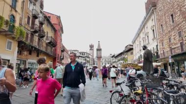 Verona, İtalya - 30 Ağustos 2025: İtalya 'nın Verona kentinin yavaş çekim görüntüleri, turistlerin güneşli bir yaz gününde ana şehirde yürüyüşlerini gösteriyor