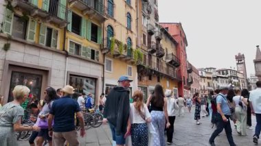 Verona, İtalya - 30 Ağustos 2025: İtalya 'nın Verona kentinin yavaş çekim görüntüleri, turistlerin güneşli bir yaz gününde ana şehirde yürüyüşlerini gösteriyor