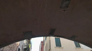 Upwards slow motion footage of the city of Venice in Italy showing the historic old buildings looking up from the famous Venices Canals on a bright sunny summers day