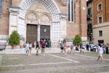 Venedik, İtalya - 30 Ağustos 2025: İtalya 'daki güzel Venedik şehrinin fotoğrafı güneşli bir günde eski tarihi binalara bakan turistleri gösteriyor. Yaz mevsimi