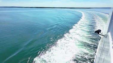 Tekneden alınan yavaş çekim görüntüleri teknenin su izlerini güneşli bir havada gösteriyor ve bir güvenlik kamerası da muhtemelen korsanlar için okyanusu izliyor.