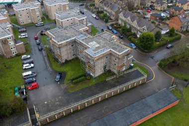 Batı Yorkshire, Leeds şehrindeki Wetherby kasabasının hava aracı fotoğrafı İngiltere 'de kışın apartmanların etrafında iskelesi olan bir apartman dairesi gösteriyor.