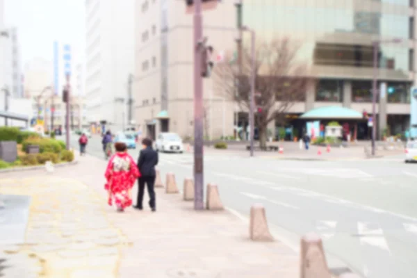 Sfondo astratto sfocato della coppia giapponese che cammina mano nella mano in città — Foto Stock