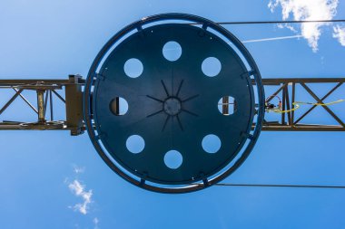 Kayak asansörünün parçası. Çelik yapının elementleri, tekerlek, çelik halatlar, gerilim, sensörler, mavi gökyüzünün arka planında elektrik kabloları.