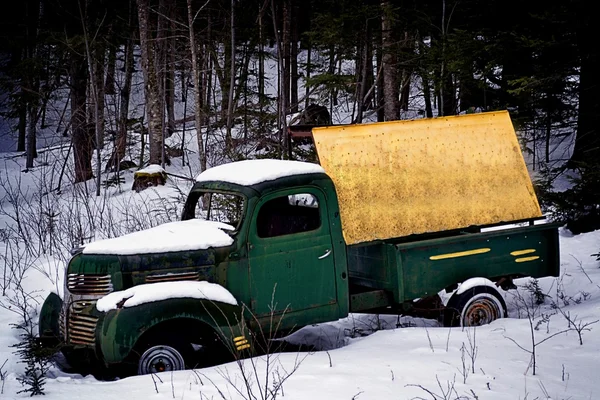 An antique truck with a blank sign abandoned in the snow Stock Image