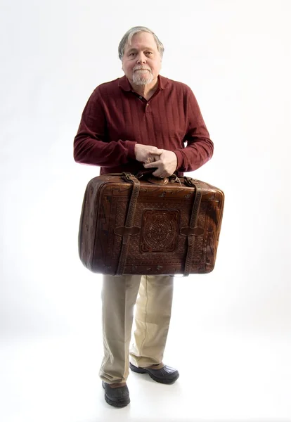 An older gentleman wearing khakis and a sweater holding an antiq — Stock Photo, Image