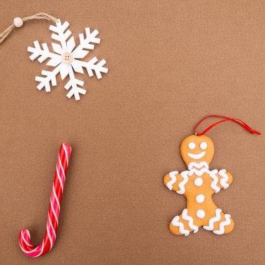 Zencefilli çörek adam, lolipop, kahverengi arka planda kar tanesi. Düz yatıyordu. Yeni yıl ve Noel konsepti. Metne yer var..