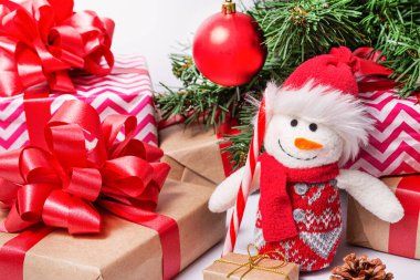 Masanın üzerinde paketlenmiş Noel hediyeleri, bir Noel ağacı, bir kardan adam, bir lolipop var. Noel ve Yeni Yıl kavramı.