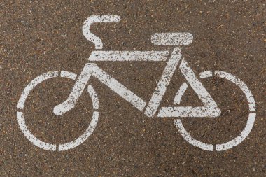 Kışın belirlenmiş bir bisiklet yolu. Bisiklet tabelası asfalta beyaz boyayla boyanmış..