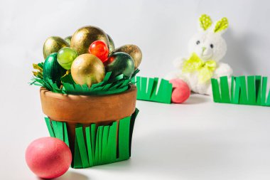 Paskalya tavşanı gardiyanları çimenlere yumurta boyadı. Yumurta ve şekerli zarif bir kap. Paskalya tatili konsepti.