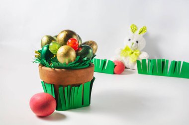 Paskalya tavşanı gardiyanları çimenlere yumurta boyadı. Yumurta ve şekerli zarif bir kap. Paskalya tatili konsepti.