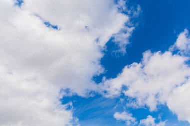 Yumuşak kümülüs ve sirrus bulutları mavi gökyüzüne karşı insan ve köpek şeklinde..