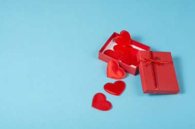 Küçük kırmızı sevgililer günü kalpleri kırmızı bir hediye kutusunda. Doğum günü ya da düğün hediyesi. Hediye alışverişi konsepti.