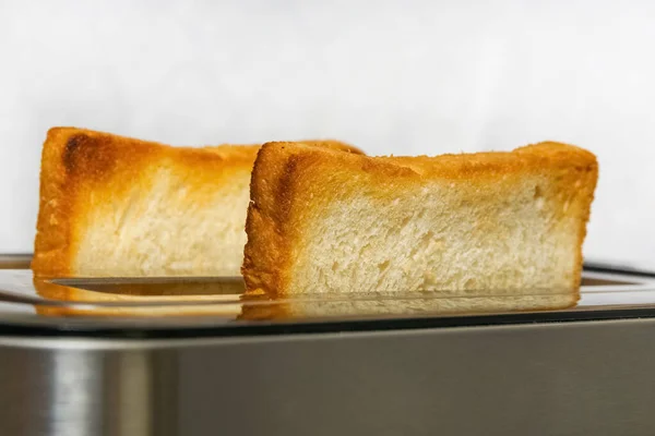 Se preparan rebanadas de pan para el desayuno. La tostadora tiene dos tostadoras crujientes — Foto de Stock