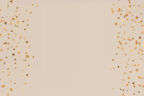 Stars golden glitter confetti isolated on blurred abstract beige background. Festive holiday background. Celebration concept. Falling magic gold particles. Invitation mock up. Top view, flat lay — Stock Vector
