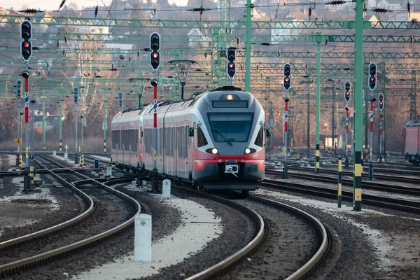 Chegada de trem de passageiros vermelho sem título à estação ferroviária. Plataforma faixa vista frontal. — Fotografia de Stock