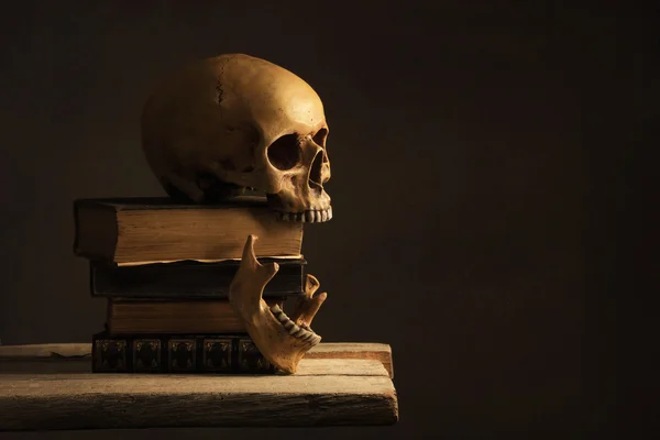 Людського черепа з щелепну кістку на старі книги — стокове фото