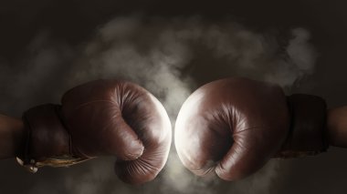 Two old brown boxing gloves hit together clipart