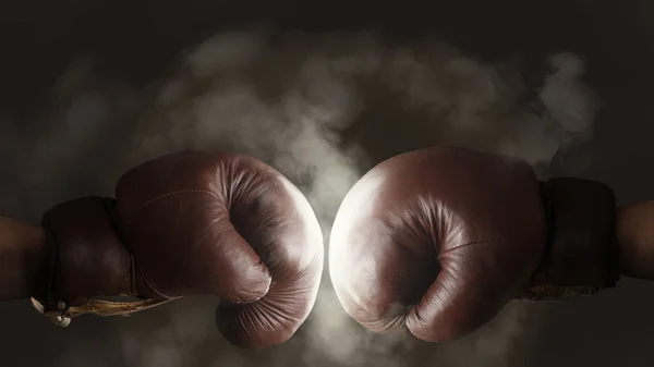 Two old brown boxing gloves hit together — Stock Photo, Image