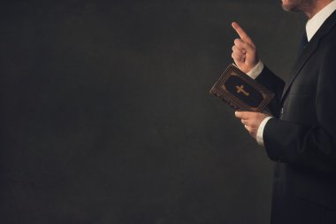 Man with a Bible and a wagging finger clipart