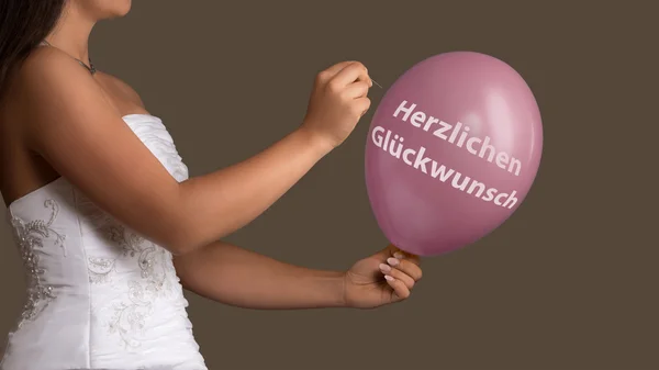 Panna młoda zniszczony balon z niemieckiego tekstu "gratulacje" — Zdjęcie stockowe