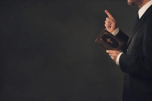 Man met een Bijbel en een kwispelende vinger Stockafbeelding