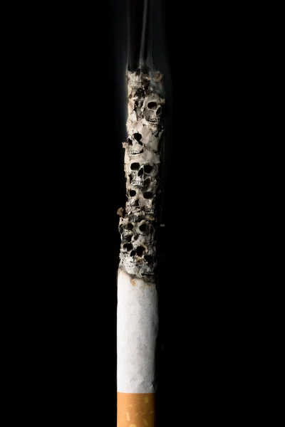 Burning cigarette with skulls and ash — Stock Photo, Image
