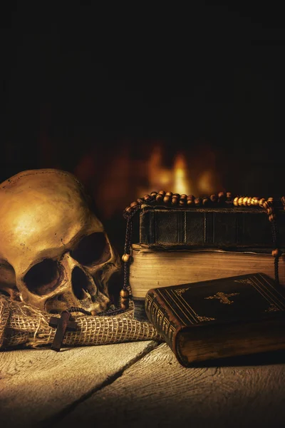 Skull with Rosary and Bible in front of a fireplace — Stock Photo, Image