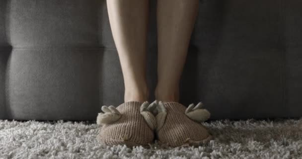スリッパを着た女性がソファに座り足を動かし — ストック動画