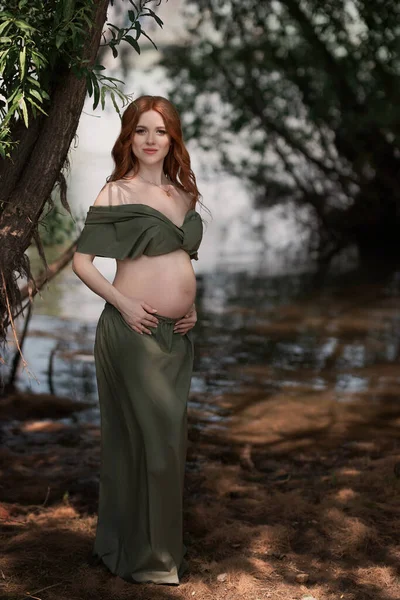 湖を背景に森の中の夏に妊娠中の赤髪の女の子 — ストック写真