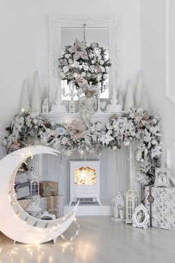 Güzel beyaz bir odada Noel süsleri ve çelenkleri olan yapay kami.