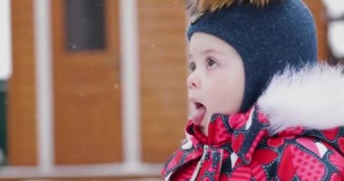 Küçük kız kışın sokakta yürüyor.