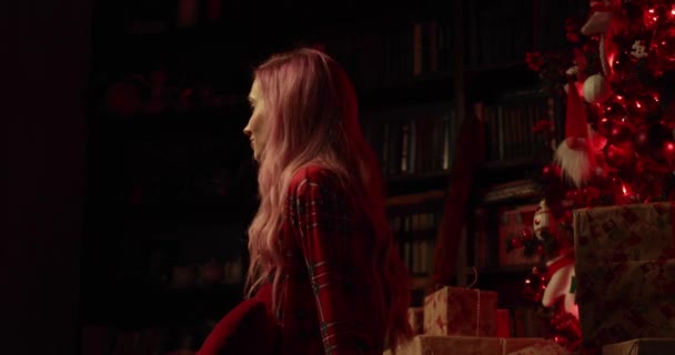Kırmızı Pijamalı Bir Kadın Noel Ağacının Yanında Oturuyor Yan Tarafa — Stok video