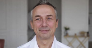 Tek gözüyle göz kırpan yetişkin bir adamın yüzü.