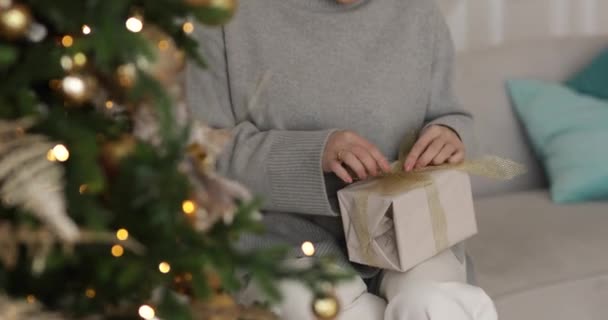 Kobieta Siedzi Kanapie Trzyma Pudełko Prezentem Noworocznym Rękach — Wideo stockowe