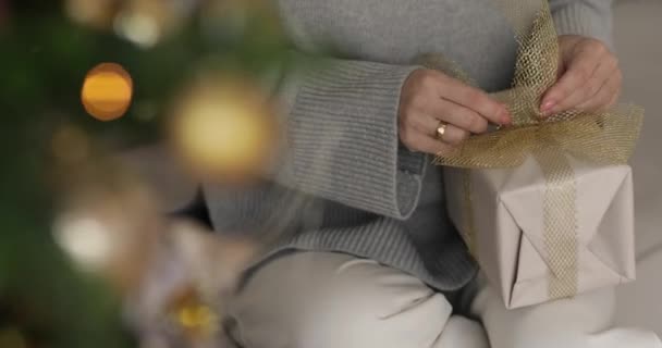Μια Γυναίκα Κάθεται Έναν Καναπέ Και Κρατά Ένα Κουτί Δώρο — Αρχείο Βίντεο
