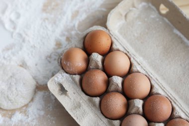 Masaya yumurta ve un koyarak.