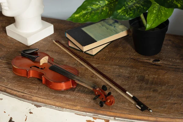 an old wooden violin lies on the dresser
