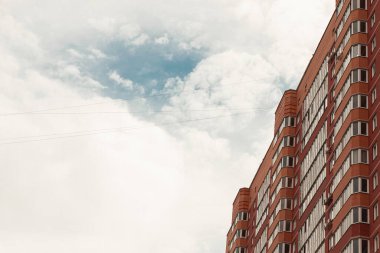 Turuncu tuğladan yapılmış tuğla bina ve mavi gökyüzü.