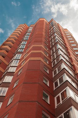 Turuncu tuğladan yapılmış tuğla bina ve mavi gökyüzü.