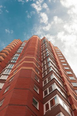 Turuncu tuğladan yapılmış tuğla bina ve mavi gökyüzü.