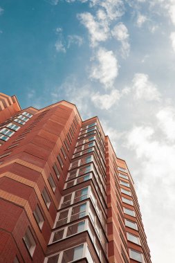 Turuncu tuğladan yapılmış tuğla bina ve mavi gökyüzü.