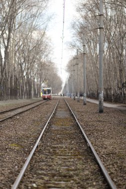 Demiryollarına yakın mesafeden bir tramvay geçiyor.