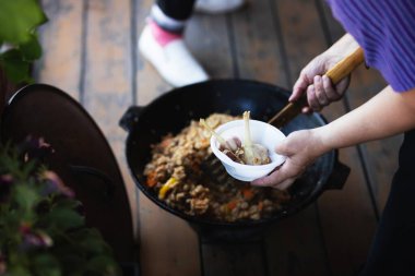 Kadın tabağa pilav koyar.