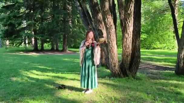 Yogi女人站在晨绿的森林里 手里拿着一只唱着Tibetan的碗 — 图库视频影像