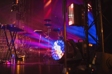 Konserden önce neon ışığı ve tiyatro ışığı altında sahnede müzik aletleri